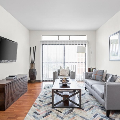Wide open living areas flooded with natural light a living room with a tv, a couch and a large window