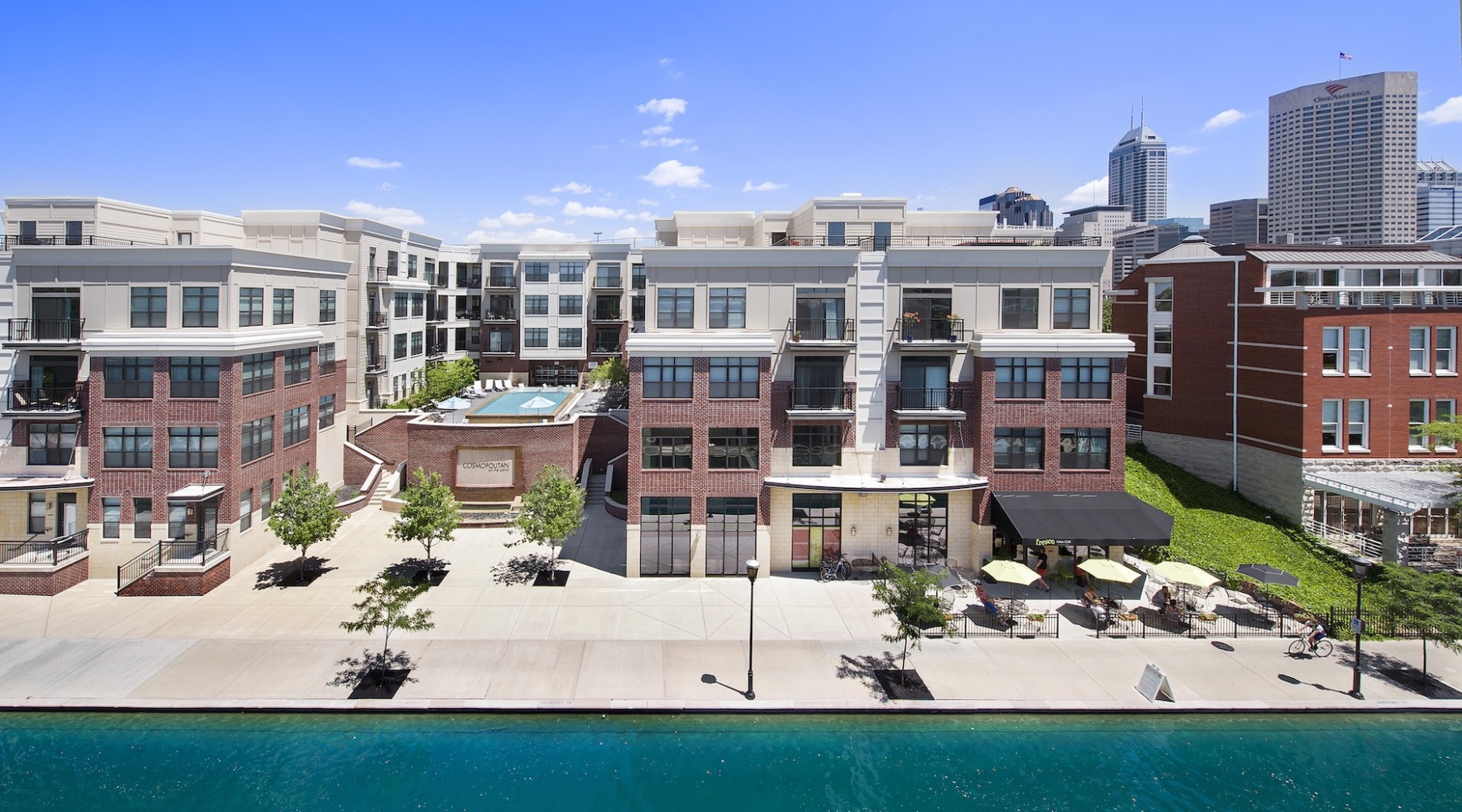 Settle into comfort at Cosmopolitan on the Canal a large building with a body of water in front of it