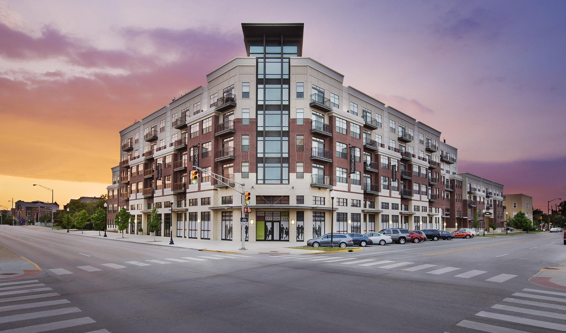 The essence of exceptional living a large building with many windows and a sunset